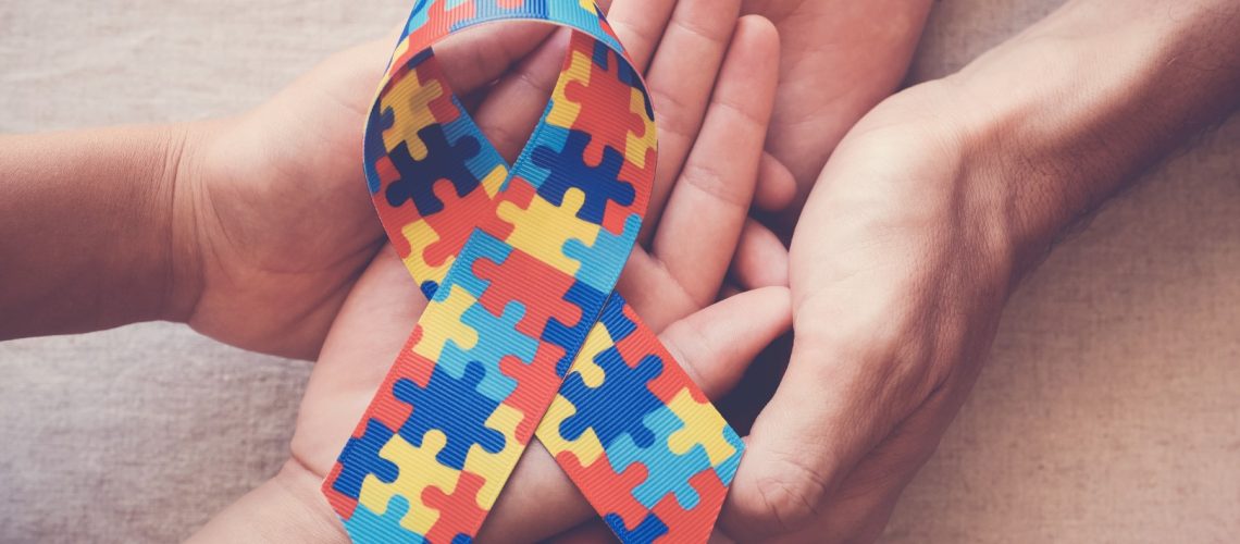 hands-holding-puzzle-ribbon-autism-awareness (Grande)